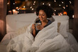 © Syda Productions - people, bedtime and rest concept - happy smiling woman in pajamas with coffee sitting in bed at night