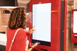 © EdNurg - A girl orders food and lunch at a fast food restaurant using a self-service kiosk or a terminal with a screen. Modern commerce equipment