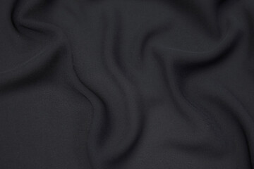 Silk or cotton fabric tissue. Dark gray or black color. Texture, background, pattern.