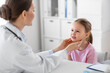 © Syda Productions - medicine, healthcare and pediatry concept - female doctor or pediatrician checking little girl patient's tonsils on medical exam at clinic