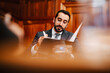 © Maskot - Confident bearded businessman with contract file sitting in board room during meeting