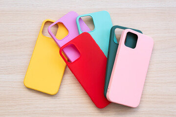 Wall Mural - Cases set for smartphone on wooden background. Silicone protection for mobile phone. Colorful silicone phone cases.