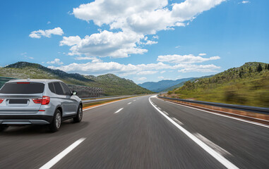 Car on a scenic road. Car on the road surrounded by a magnificent natural landscape.