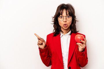 Wall Mural - Young business hispanic woman holding an apple isolated on white background pointing to the side