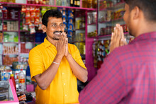 Smiling Groceries Merchant Greeting By Doing Namaste To Customer At Kirana Shop - Concept Of Indian Culture, Small Business And Communication.