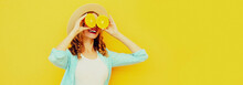 Summer Portrait Of Happy Smiling Woman Covering Her Eyes With Slices Of Orange And Looking For Something Wearing Straw Hat On Yellow Background, Blank Copy Space For Advertising Text