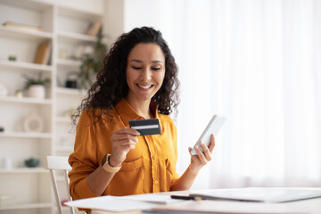 Wall Mural - Happy Arabic Female Shopping Online Using Cellphone In Office