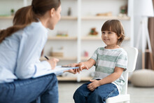 First Meeting With Patient. Friendly Professional Woman Child Psychologist Greeting Cute Little Boy, Touching His Hand