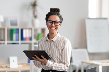 Poster - Happy entrepreneur young woman holding digital tablet, using modern technologies in business, office interior