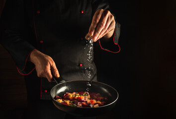 Wall Mural - Professional chef adds salt to a steaming hot pan. Menu idea for a hotel with advertising space. Asian cuisine