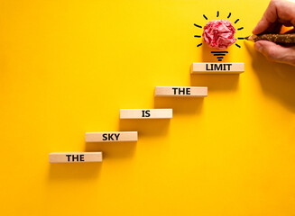 Sky is limit symbol. Concept words The sky is the limit on wooden blocks. Businessman hand. Beautiful yellow table yellow background. Business motivational stress spice of life concept. Copy space.