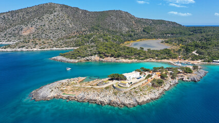 Aerial drone photo of iconic Aponisos bay and lake with clear turquoise sea and pine trees,  Agistri island, Saronic gulf, Greece