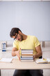© Elnur - Young male student preparing for exams in the classroom