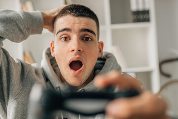 Wall Mural - young man playing with video game controller