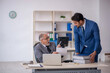 © Elnur - Old male boss and young male employee working in the office