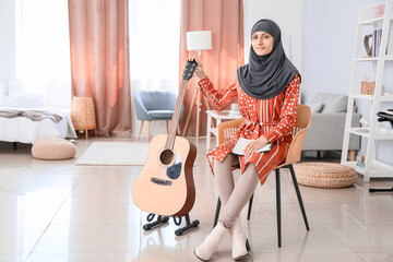 Wall Mural - Muslim music teacher with guitar at home