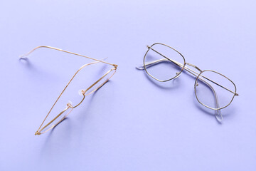 Different stylish eyeglasses on lilac background