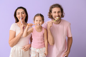 Wall Mural - Little girl with her parents brushing teeth on lilac background