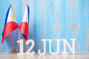 Wall Mural - Wooden text of June 12th with Philippines flags. Philippines Independence day and happy celebration concepts