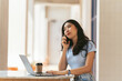 © PaeGAG - Asian woman in casual clothes is happy and cheerful while communicating with her smartphone and working in a coffee shop.