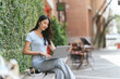 © PaeGAG - Portrait of beautiful Asian woman sitting outdoors at coffee shop restaurant during summer, using smart wireless technology computer laptop and smartphone, relaxing coffee break at cafe restaurant.