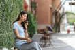 © PaeGAG - Portrait of beautiful Asian woman sitting outdoors during summer, using smart wireless technology computer laptop and smartphone, relaxing coffee break at cafe restaurant.