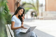 © PaeGAG - Portrait of beautiful Asian woman sitting outdoors during summer, using smart wireless technology computer laptop and smartphone, relaxing coffee break at cafe restaurant.