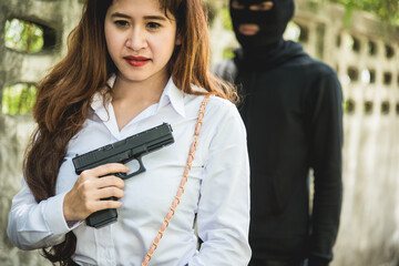 Wall Mural - Young woman self defence putting gun in her small handbag, female hide gun in his chest, self-defense criminal concept