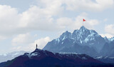Business success challenge and climbing a high mountain metaphor as a businessman with a goal of retreiving a red flag from the peak or summit