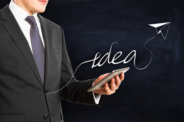 Aufkleber - Close up of businessman hand holding mobile phone with creative idea airplane sketch on chalkboard background. Innovation, startup and genius concept.
