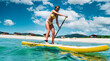 Woman stand up on paddle board in turquoise transparent sea. Big yellow board in turquoise water.