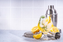 Infused Rosemary Lemon Drink. Cold Detox Citrus Lemonade With Carbonated Fizz Water, Lemon Slices And Rosemary Sprig, White Tiled Background Copy Space