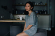 © Maskot - Emotionally stressed woman sitting by dining table in kitchen at home