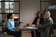 © AnnaStills - Young woman having meeting with employers at office, she getting a new job