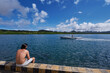 © luengo_ua - Young man sitting on wooden fishing pier with beautiful tropical sea view.