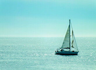  A sailing boat in a beautiful blue sea, a photo of a sailboat in turquoise ocean, sun rays hitting the sea in the afternoon, Barcelona, Spain, Marina in Barcelona, selective focus