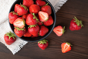 Canvas Print - Top-down shot of strawberry on black wooden table. Fresh tasty strawberry