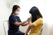 © bennnn - Asian Preteen Girl Getting Vaccinated, Receiving Coronavirus Vaccine Injection in clinic.