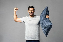 Cheerful Caucasian Man With Pillow Showing Bicep
