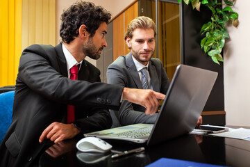 Canvas Print - Two business partners working at a laptop in their office