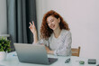 © dianagrytsku - Freelance business woman with ginger hair sits in front of laptop computer, communicates with colleagues via video conference, sits at desktop, drinks coffee, has happy expression. Distance job