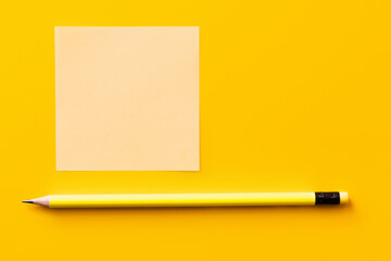 Canvas Print - top view of sharp pencil near blank paper note on yellow.