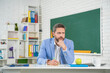 pondering school tutor in classroom at blackboard