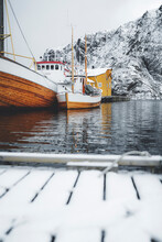 Fishing Boats Moored In The Harbor In The Cold Arctic Sea, Nusfjord, Nordland County, Lofoten Islands