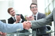© ASDF - handshake of business people on a blurred office background.