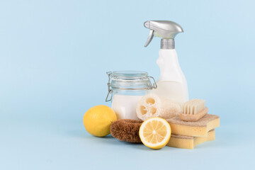 Wall Mural - Cleaning set with organic detergent products. Spray bottle, baking soda, lemon, citric acid, natural dishcloths against blue background with copy space. Homemade improvised cleaning products