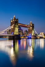 Tower Bridge And The City Of London Skyscrapers Reflecting In River Thames At Sunset, London