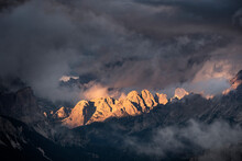 Light Rays Hitting Dolomites Mountain Peaks At Sunset, Surrounded By Low Clouds And Mist, Cortina D'Ampezzo, Dolomites, Veneto