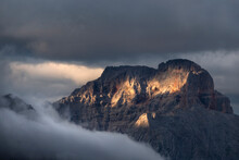 Sunset On Croda Rossa D'Ampezzo Mountains Surrounded By The Fog And Darkness With Only A Few Spots Of Sun Light, Dolomites, Veneto