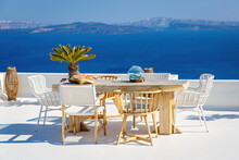A Sun Terrace For Rest With A Wooden Table And Chairs In Thira, Santorini Island, Greece